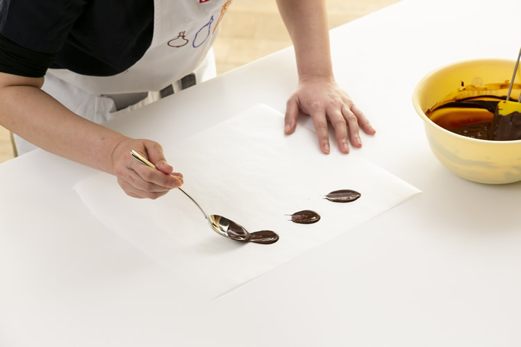 スプーンを使い飾りチョコを作っている写真