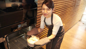 池田愛実さんがミーレオーブンにパンを入れるところ